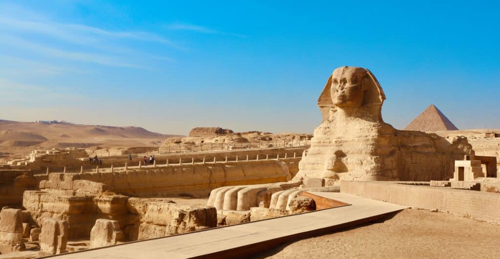 Le Grand Sphinx de Gizeh, statue monumentale à tête humaine et corps de lion, situé devant les pyramides sous un ciel dégagé
