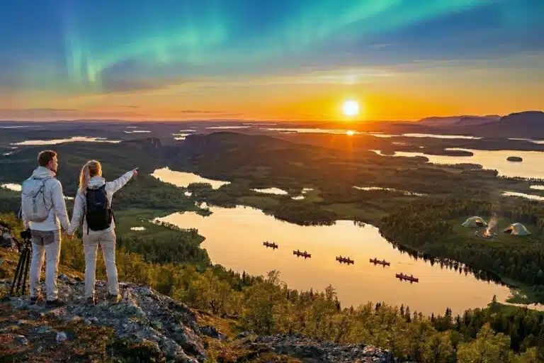 Couple admirant un coucher de soleil avec aurores boréales au-dessus des lacs en Laponie en été