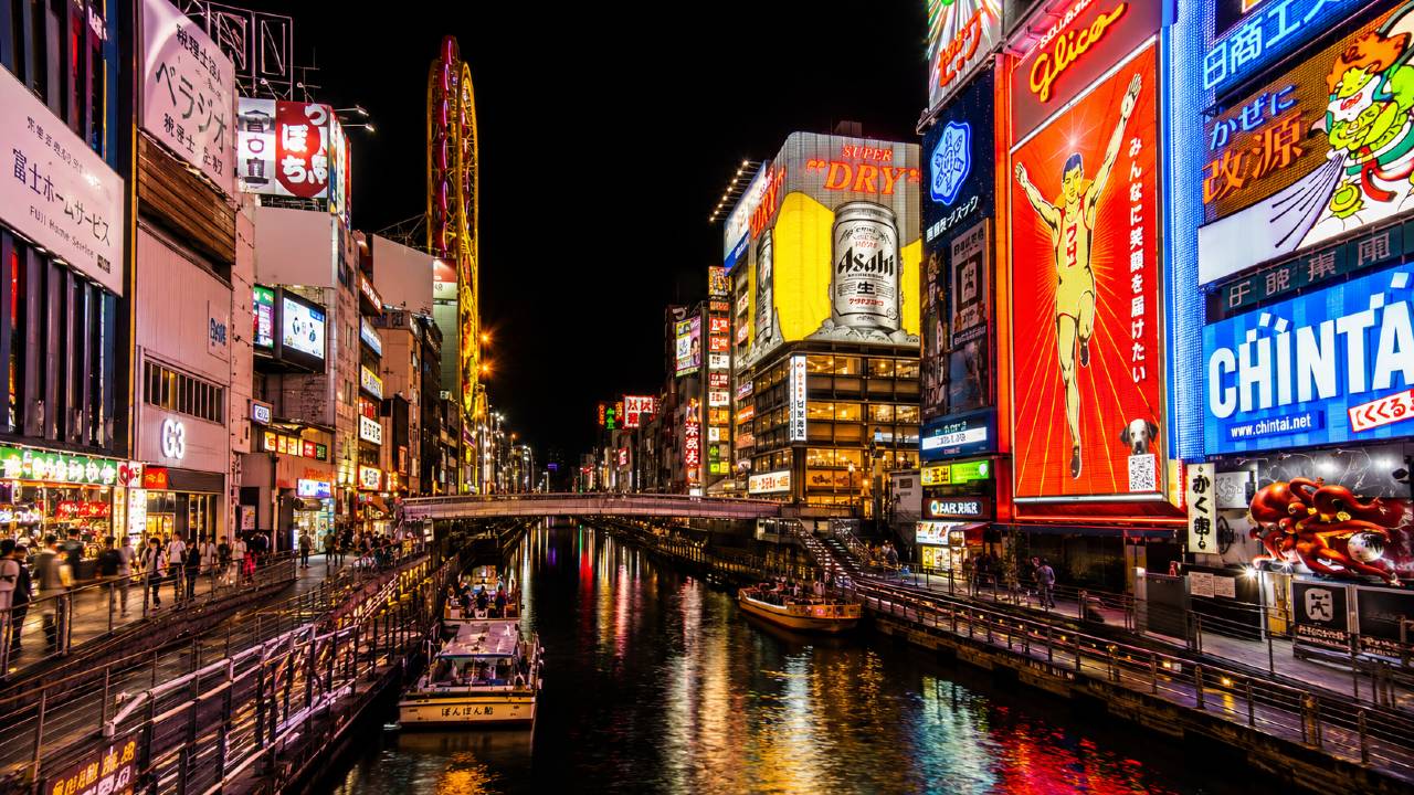 Osaka voyage au Japon : quartier de Dotonbori de nuit avec reflets de néons sur le canal, enseigne Glico et restaurants